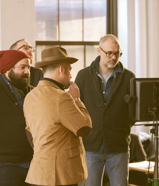 group of men gathered around screen